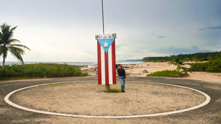 The author Vanessa Ramos, standing next to Puerto Rico's flag in Paseo Lineal