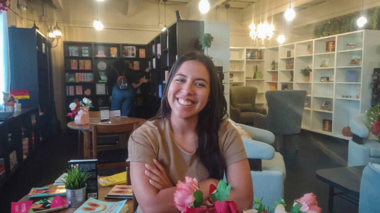 The author Vanessa Ramos smiling for a photo on a coffee shop