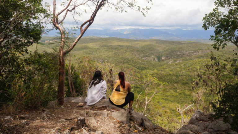 The author Vanessa Ramos with a woman admiring the scenic view of greenery in Puerto Rico
