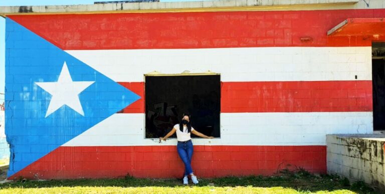 The author with a flag of Puerto Rico mural in the background