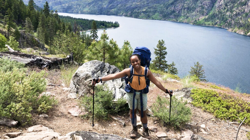 The author Chelsea Booker posing with scenic view of Lake Chelan, Washington state facts